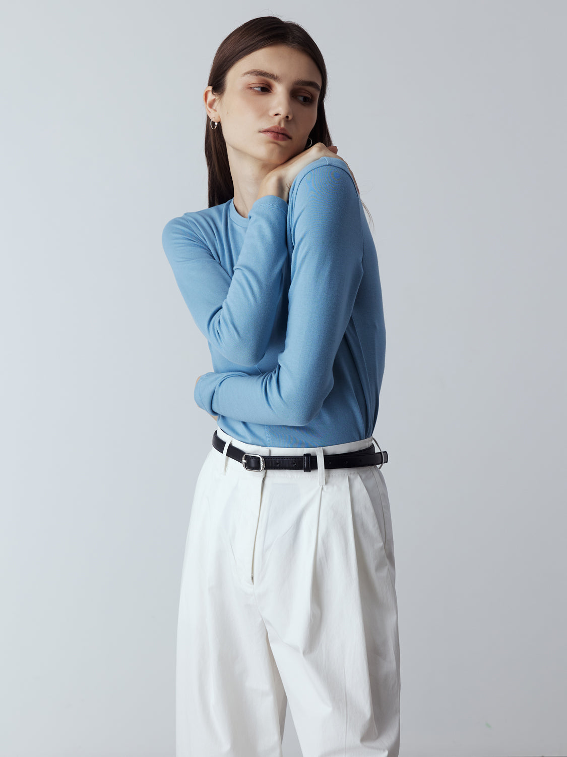 Blue : Model is wearing the Fitted Long Sleeve T-Shirt in Blue, which comes with a rounded crew neckline and a centre front stitch line. Arm-hugging but gives a relaxed bodice. Worn with Cotton Tailored Trousers in White and metallic silver heels.