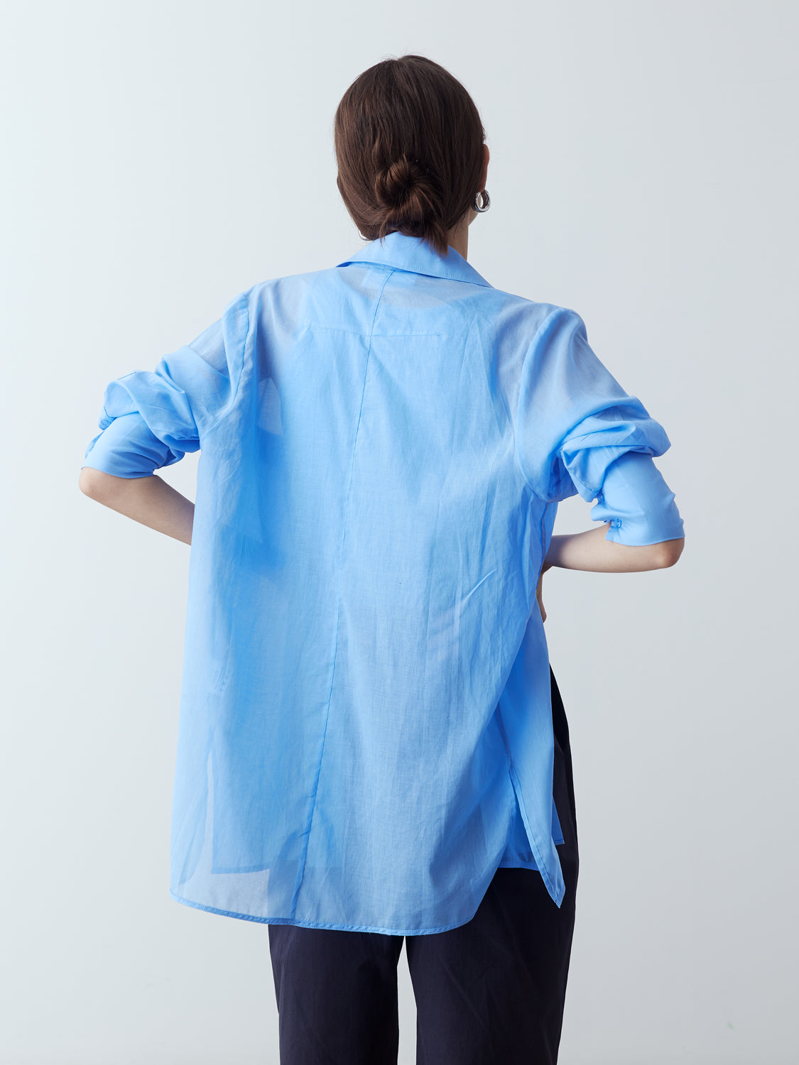 light blue : Model is wearing the Sheer Long Sleeve Shirt in Light Blue, which comes with a straight hem, front placket with buttons and a left breast pocket. Worn with the Jersey Tank in Light Blue, the Cotton Tailored Trousers in Navy and metallic silver heels.