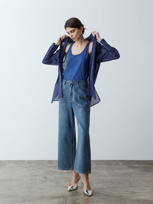 Model is wearing the Sheer Long Sleeve Shirt in Dark Blue, which comes with a straight hem, front placket with buttons and a left breast pocket. Worn with the Jersey Tank in Dark Blue, the Denim Straight Cut Jeans and metallic silver heels.