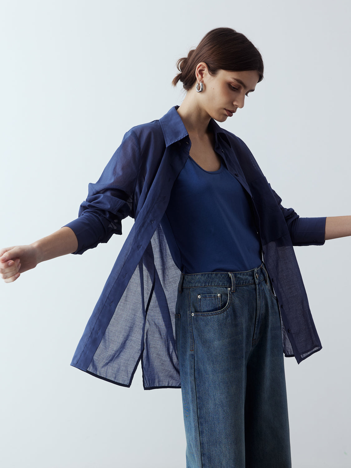 dark blue : Model is wearing the Sheer Long Sleeve Shirt in Dark Blue, which comes with a straight hem, front placket with buttons and a left breast pocket. Worn with the Jersey Tank in Dark Blue, the Denim Straight Cut Jeans and metallic silver heels.