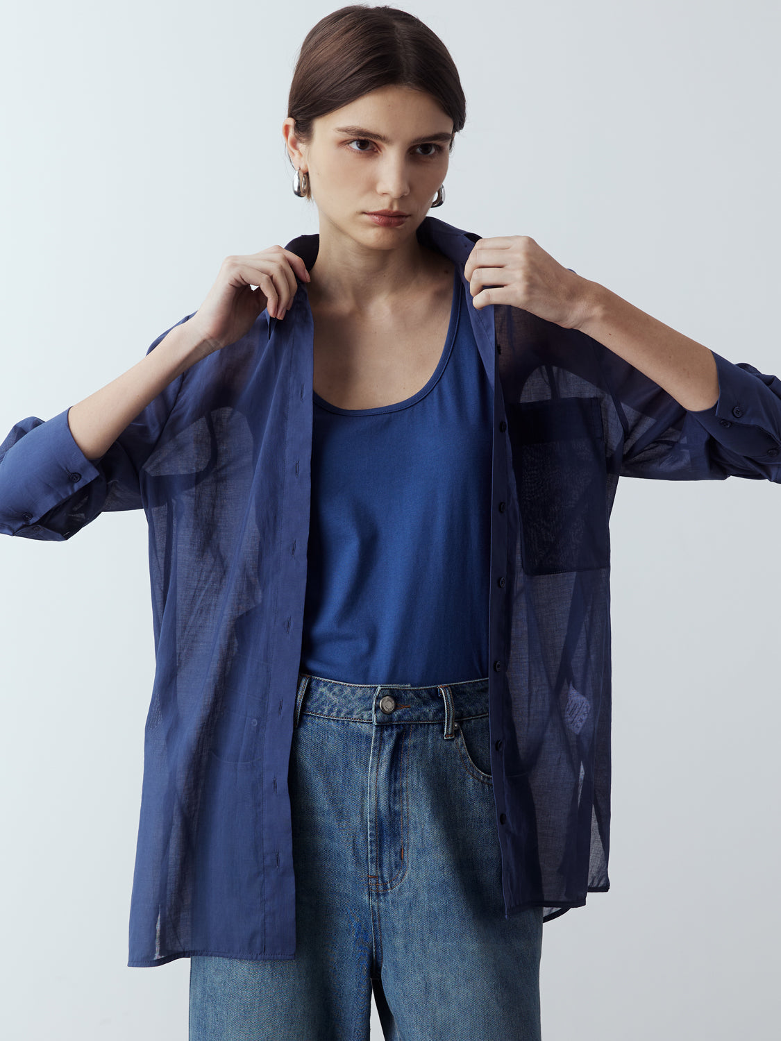 dark blue : Model is wearing the Sheer Long Sleeve Shirt in Dark Blue, which comes with a straight hem, front placket with buttons and a left breast pocket. Worn with the Jersey Tank in Dark Blue, the Denim Straight Cut Jeans and metallic silver heels.