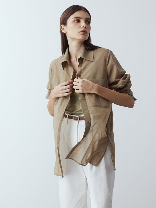 Model is wearing the Sheer Long Sleeve Shirt in Khaki, which comes with a straight hem, front placket with buttons and a left breast pocket. Worn with the Jersey Tank in Khaki, the Cotton Tailored Trousers in White and white strappy heels.