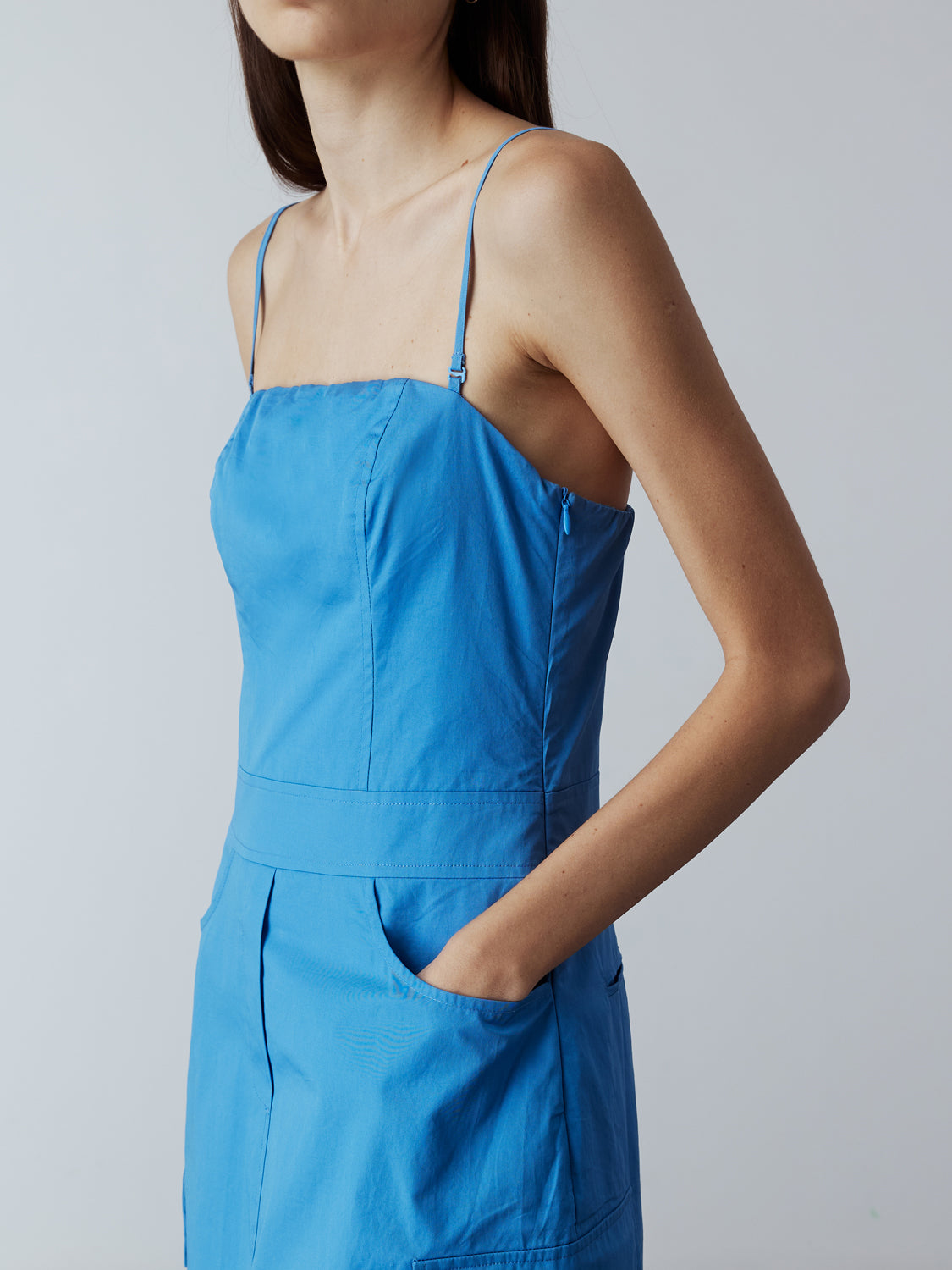 blue : Model is wearing the Adjustable Cargo Dress in Blue, which comes with back pockets, and cargo and slash pockets at the sides. This is a sleeveless garment with adjustable spaghetti straps. Can also be worn as a tube dress. Worn with Fitted Long Sleeve T-Shirt in Blue layered under and metallic silver heels.