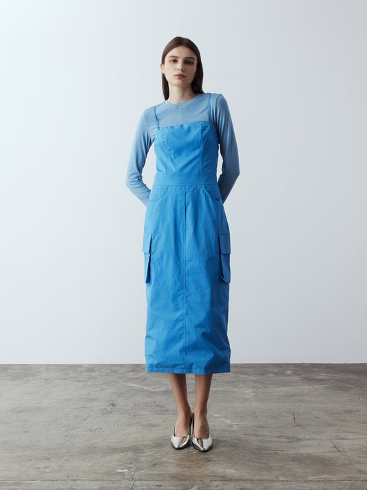 Model is wearing the Adjustable Cargo Dress in Blue, which comes with back pockets, and cargo and slash pockets at the sides. This is a sleeveless garment with adjustable spaghetti straps. Can also be worn as a tube dress. Worn with Fitted Long Sleeve T-Shirt in Blue layered under and metallic silver heels.